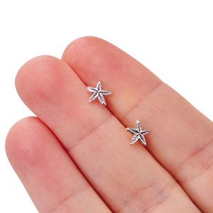 May include: A pair of silver starfish stud earrings. The earrings are small and delicate, and they would make a great gift for someone who loves the ocean.