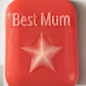 May include: A red square-shaped plaque with the words "Best Mum" in white lettering and a white five-pointed star in the centre.