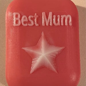 May include: A red rectangular soap bar with the words "Best Mum" embossed in white and a white star in the centre.