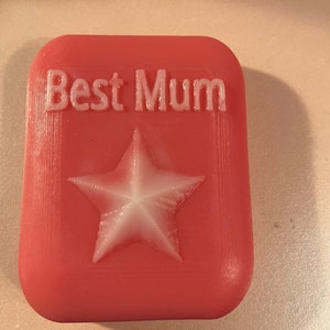 May include: A pink rectangular soap with the words "Best Mum" embossed in white and a white star in the centre.