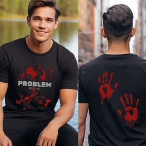 Può includere: Maglietta nera con una grafica rossa di schizzi di sangue e il testo "PROBLEM SOLVED" sul davanti. La parte posteriore della maglietta presenta due impronte di mani rosse con sangue che cola.