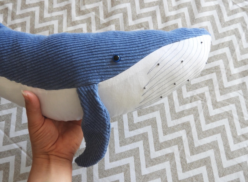 Peut inclure: Une peluche baleine bleue avec un ventre blanc et des coutures d&eacute;taill&eacute;es. La baleine a une texture en velours c&ocirc;tel&eacute; et un petit &oelig;il noir. Le jouet est con&ccedil;u pour ressembler &agrave; une baleine et convient aux enfants.
