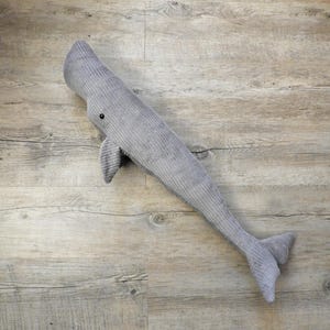 K&ouml;nnte beinhalten: Ein graues Wal-Pl&uuml;schtier aus Cord mit einem kleinen schwarzen Auge und Flosse. Der Wal liegt auf einer Holzoberfl&auml;che. Das Pl&uuml;schtier ist etwa 76 cm lang.