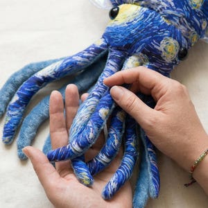 Puede incluir: Un peluche de pulpo con un patr&oacute;n arremolinado azul y blanco que recuerda a "La noche estrellada" de Van Gogh. El juguete tiene largos y suaves tent&aacute;culos en tonos azules y una pieza para la cabeza blanca y sedosa. Ojos de bot&oacute;n negros y un pico amarillo completan el dise&ntilde;o.