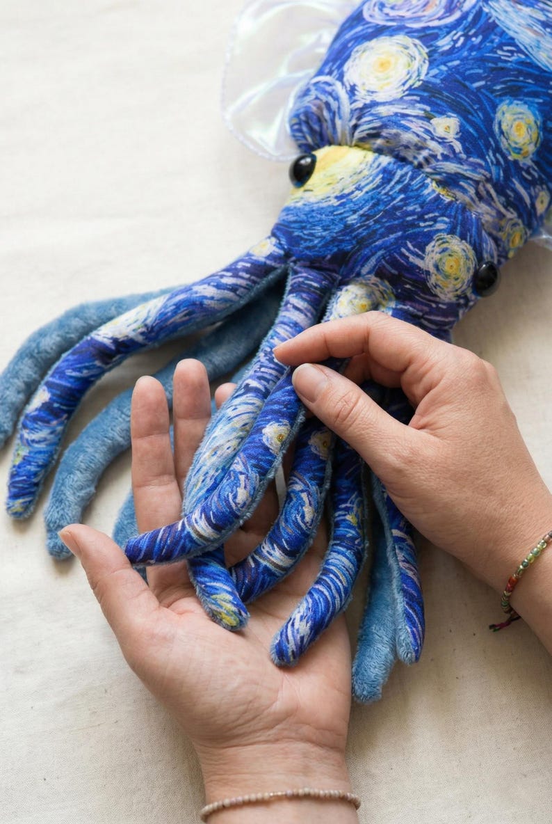 Puede incluir: Un peluche de pulpo con un patr&oacute;n arremolinado azul y blanco que recuerda a "La noche estrellada" de Van Gogh. El juguete tiene largos y suaves tent&aacute;culos en tonos azules y una pieza para la cabeza blanca y sedosa. Ojos de bot&oacute;n negros y un pico amarillo completan el dise&ntilde;o.