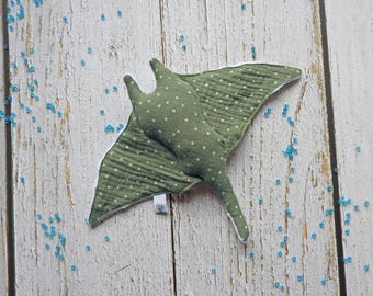 May include: A green and white polka dot fabric manta ray toy. The toy is made of soft, plush fabric and has a white belly.