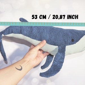 Peut inclure: Une peluche baleine bleue de 53 cm de long, avec un ventre et des nageoires bleu clair. La baleine est faite d'un tissu textur&eacute;, de type velours c&ocirc;tel&eacute;, et a un petit &oelig;il noir. Le jouet est pr&eacute;sent&eacute; sur fond blanc.