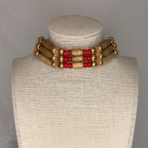 Choker bone hair pipe with brass and red whiteheart beads. Soft buckskin ties.