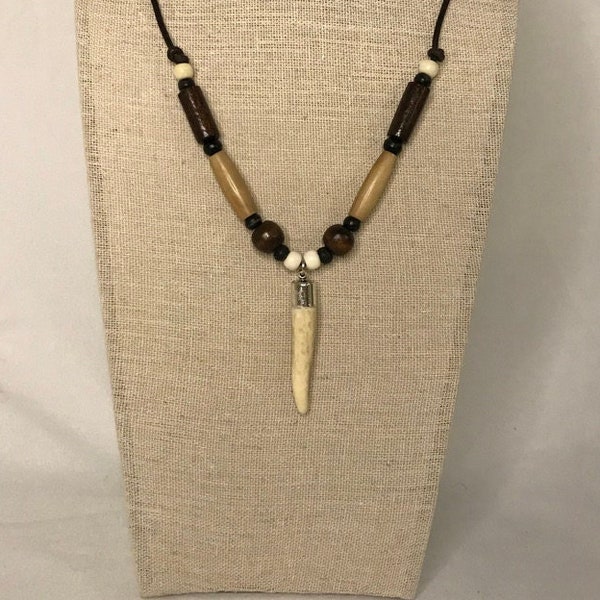 Polished deer antler tipped leather necklace.  Silver capped antler tip with, bone, horn and wood beads on leather.