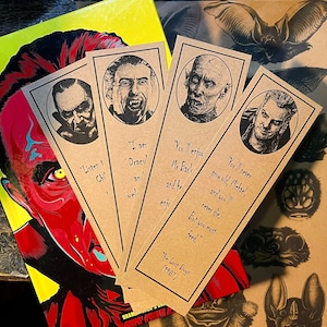 Puede incluir: Cuatro marcapáginas marrones con ilustraciones en blanco y negro de personajes de la película The Lost Boys. Los marcapáginas presentan citas de la película, incluyendo "Soy Dracula" y "¡Nunca envejecerás, Michael!"