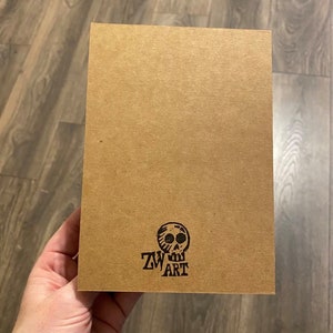 May include: A brown card with a black skull and the text "ZW ART" printed on it.