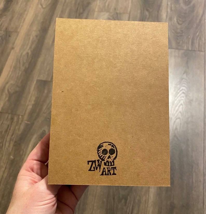 May include: A brown card with a black skull and the text "ZW ART" printed on it.