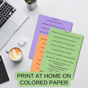 May include: Three printable affirmation cards on different colored paper. The cards are green, purple, and orange. The text on the cards includes positive affirmations about self-love and overcoming challenges.