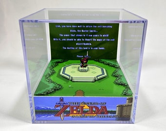 May include: A clear acrylic display case with a miniature diorama of the video game The Legend of Zelda: A Link to the Past. The diorama features Link standing on a platform in a green forest. The text "Link, you have done well to obtain the evil-banishing blade, the Master Sword..." is visible in the background.