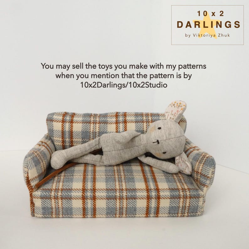 May include: A grey stuffed bunny lies on a miniature sofa with a blue, brown, and cream plaid pattern. The image includes the text "10 x 2 DARLINGS by Viktoriya Zhuk" and a message about selling toys made with the patterns.
