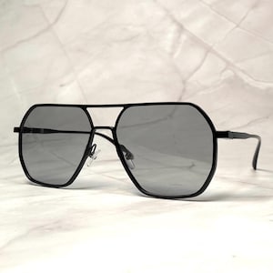 May include: Black aviator sunglasses with a geometric frame and dark gray lenses.