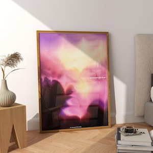 Könnte beinhalten: Ein gerahmter Kunstdruck mit einem lebendigen, abstrakten Design in Rosa-, Lila- und Gelbtönen. Der Druck enthält den Text "loving someone you love". Das Kunstwerk wird auf einem Holzboden ausgestellt.