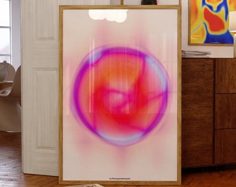 May include: A framed abstract art print featuring a pink, orange and blue orb in the centre against a white background. The print is framed in a light wood frame and has the text "by RainbowShapes" at the bottom.