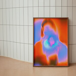 May include: A framed abstract print with a blurred image of a person's face in shades of orange, pink, and blue.