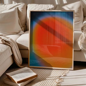 Könnte beinhalten: Ein gerahmter abstrakter Kunstdruck mit einem großen, leuchtend orangefarbenen und gelben Kreis in der Mitte, umgeben von einem Farbverlauf in Blau und Lila.