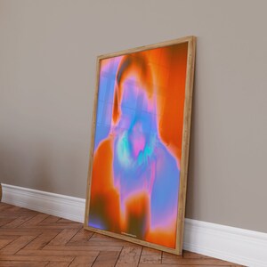 May include: Abstract art print in a wooden frame. The print features a colorful, swirling design in shades of orange, blue, and purple.