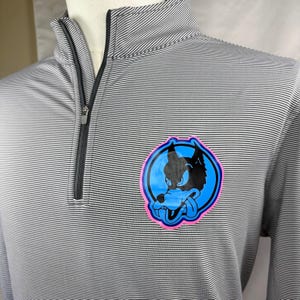 以下が含まれることがあります： グレーと白のストライプのクォータージッププルオーバーシャツ。左胸にピンクの縁取りのある黒と青のオオカミのグラフィックが特徴です。黒いジッパーとモックネックカラーが付いています。