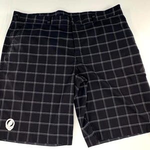 Puede incluir: Pantalones cortos a cuadros negros y grises con cierre de botón y cremallera. Los pantalones cortos tienen un pequeño gráfico blanco en la pierna izquierda. Están hechos de un material ligero y tienen bolsillos.