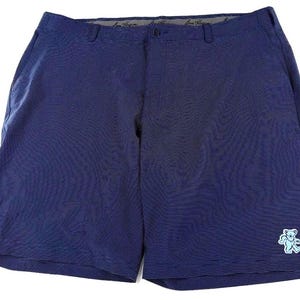 Puede incluir: Pantalones cortos azul marino con un sutil patrón texturizado. Cuentan con cierre de botón y un pequeño gráfico de oso azul claro en la parte inferior derecha. Los pantalones cortos tienen un diseño clásico y a medida.