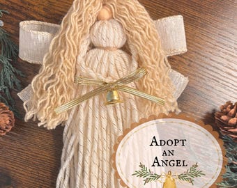 Può includere: Un angelo decorativo fatto a mano in filo con capelli in corda color crema, testa in perla di legno e ali in nastro di tessuto beige. Un nastro metallico dorato è legato in vita con una piccola campanella dorata. Il testo recita ADOPT AN ANGEL.