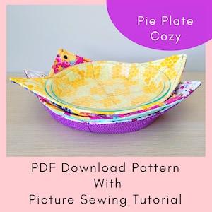 May include: A purple, yellow, and blue fabric pie plate cozy. The cozy is made of multiple layers of fabric and has a honeycomb pattern. The text "Pie Plate Cozy" is written in a purple circle at the top of the image. The text "PDF Download Pattern With Picture Sewing Tutorial" is written at the bottom of the image.