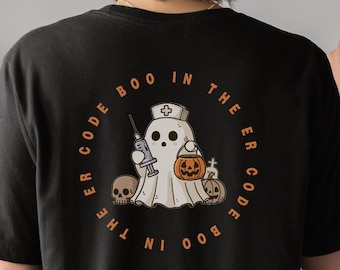 Op de afbeelding: Zwart t-shirt met een cirkelvormig ontwerp met de tekst "ER Code Boo in the ER Code Boo". Het ontwerp toont een spook met een verpleegstershoed, met een spuit en een pompoen, met schedels en pompoenen. Een Halloween-thema grafisch t-shirt.