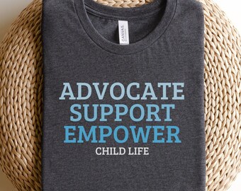 Op de afbeelding: Een donkergrijs T-shirt met de tekst "Advocate Support Empower Child Life" in blauwe letters.