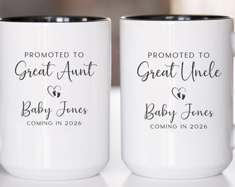 May include: Two white ceramic mugs with black handles and rims. The mugs have the text "Promoted to Great Aunt" and "Promoted to Great Uncle" in elegant script, along with "Baby Jones" and "Coming in 2026".