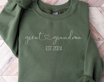 May include: A green sweatshirt with the text "great grandma est. 2024" in white.