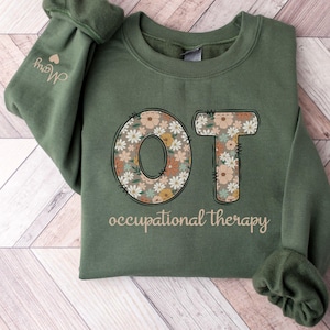May include: Green sweatshirt with the letters "OT" in floral print and the text "occupational therapy" below.