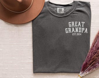 May include: A dark gray t-shirt with the text "GREAT GRANDPA EST. 2024" in white.