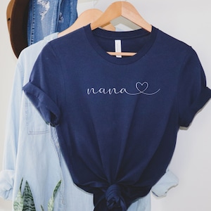 Peut inclure: Un t-shirt bleu marine avec le mot "nana" et un petit c&oelig;ur dessin&eacute; en blanc.