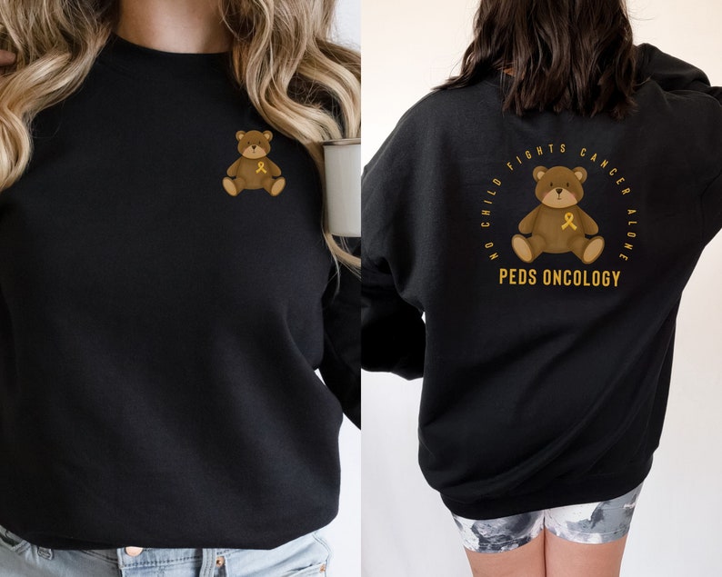 May include: Black sweatshirt with a gold ribbon teddy bear graphic on the front and a gold ribbon teddy bear graphic with the text "No child fights cancer alone. Peds Oncology" on the back.