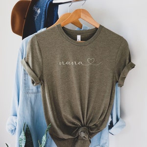 Peut inclure: Un t-shirt vert avec le mot "nana" et un c&oelig;ur dessin&eacute; en blanc.