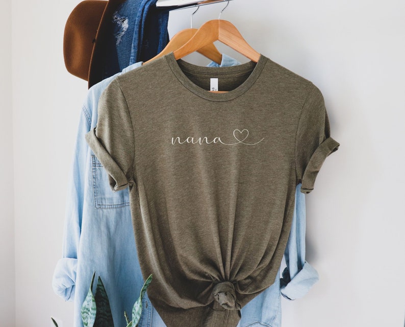 Peut inclure: Un t-shirt vert avec le mot "nana" et un c&oelig;ur dessin&eacute; en blanc.