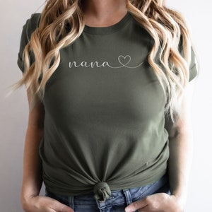 Peut inclure: Un t-shirt vert avec le mot "nana" et un c&oelig;ur dessin&eacute; en blanc.