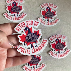 May include: Five white stickers with red maple leaf designs. Each sticker features a cartoon goose with the text "COBRA CHICKEN" and the phrase "ALTER EGO OF POLITE CANADIANS".
