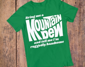 May include: Green t-shirt with white text that reads "Bring me a Mountain Dew and tell me I'm ruggedly handsome."
