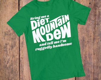 May include: Green t-shirt with white text that reads "Bring me a Diet Mountain Dew and tell me I'm ruggedly handsome."
