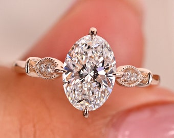 May include: A rose gold engagement ring with an oval-shaped center diamond and two smaller diamonds on each side. The ring is set on a delicate band.