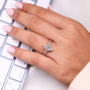 Kite side diamond ring with tapered shank design.