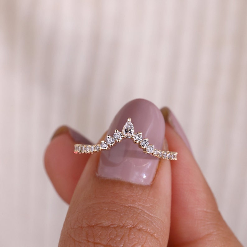 this band was made with pear center stone and the side stone are round brilliant cut.