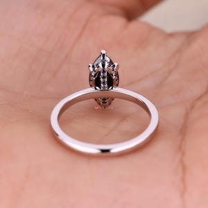 Round cut engagement ring featuring a sparkling marquise moissanite stone.