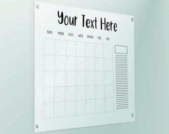 May include: White dry-erase calendar with a black frame and the text "Your Text Here" at the top. The calendar has spaces for each day of the week, from Sunday to Saturday, and a notes section on the right.