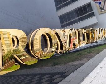 May include: A gold-colored sign with the text "ROYAL TOBACCO" in raised, 3D letters.
